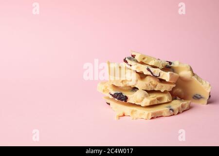 White chocolate pieces on pink background. Sweet food Stock Photo