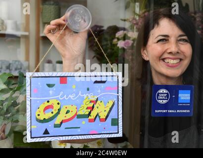 Michelle MacArthur from Moss Flowers in Glasgow displays a “WE'RE OPEN” sign designed by artist Yukai Du, which has been created to celebrate the American Express Shop Small campaign and to help Scottish retailers welcome people back to our high streets. Stock Photo