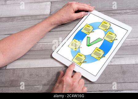 Document validation concept shown on a tablet used by a woman Stock Photo