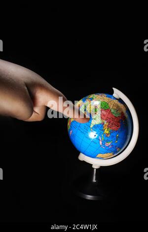 Pointing India in the globe. Earth globe isolated on a black background. School globe on black background. Stock Photo