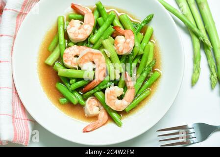 Asparagus Shrimp Seafood Cooked Health Food / Stir fried shrimps with asparagus green on white plate Stock Photo