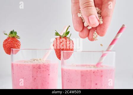 Strawberry milk shake in glass with straw and fresh berries on white background Stock Photo