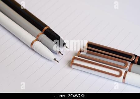 Colorful pens on a sheet of a notebook Stock Photo