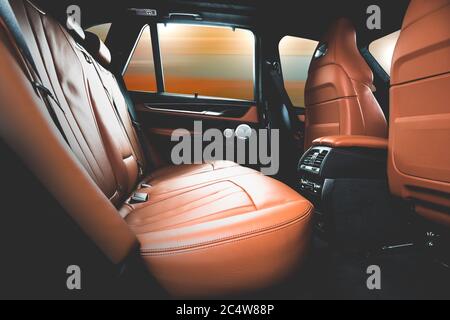 back seats of modern luxury car, red leather interior