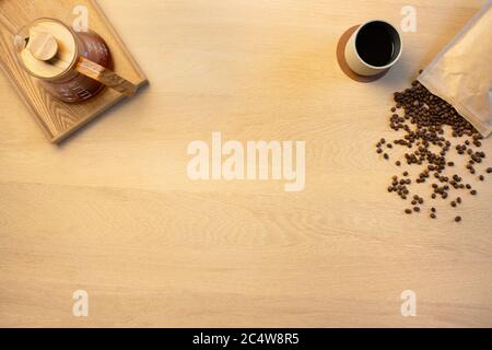 Overhead view of coffee pot and beans by cup on wooden table Stock Photo