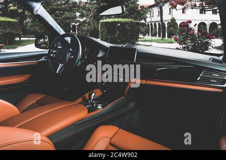 Orange red sand leather luxury car inside Interior - steering wheel, shift lever and dashboard. Stock Photo