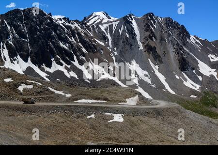 Truck driving on a high road in the Tian Shan mountains of Kyrgyzstan Stock Photo