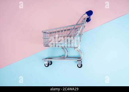 empty shopping cart over colour background, mini metal cart isolated on color background Stock Photo