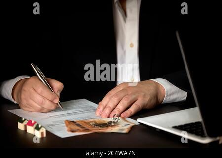 Sales agent signing the contract of sale or rental of a property. Concept home Stock Photo
