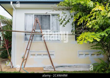 Trestles set up to paint exterior of a house, partially painted Stock Photo