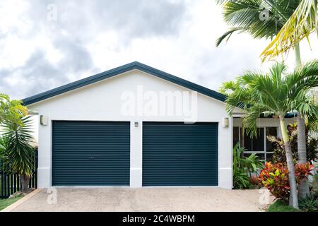Freshly painted house with double garage, gable end and tropical garden Stock Photo