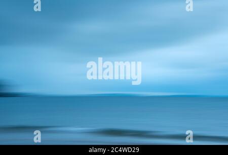 Abstract image of blue sea waves and clouds. Image captured using intentional camera movement technique for dreamy effect. Stock Photo