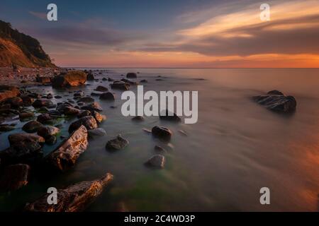 Cliff and stony beach in Wolin National Park in the light of the setting sun, Poland Stock Photo