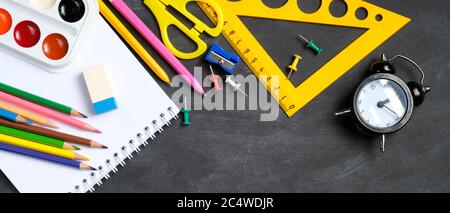 Back to school banner template. Flat lay colorful school supplies on black board background. Top view, overhead. Stock Photo