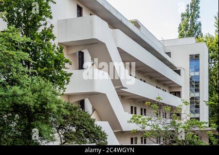 Isokon Flats, also known as Lawn Road Flats, on Lawn Road, Hampstead, London NW3, is a reinforced concrete block of 36 flats (originally 32), designed by Canadian engineer Wells Coates for Molly and Jack Pritchard. The designs for the flats were developed between 1929–1932 and opened on 9 July 1934 as an experiment in minimalist urban living. Most of the 'existenz minimum' flats had tiny kitchens as there was a communal kitchen for the preparation of meals, connected to the residential floors via a dumb waiter. Services, including laundry and shoe-polishing, were provided on site. It has a blu Stock Photo