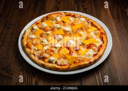 Four kinds of cheese pizza, wooden background, low key Stock Photo