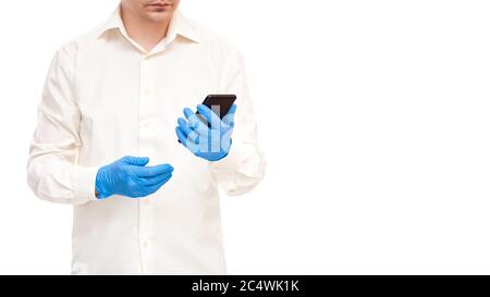 doctor in white shirt and blue sterile gloves holds a cell phone in his hand, medical concept on theme of mobility and accessibility of services onlin Stock Photo