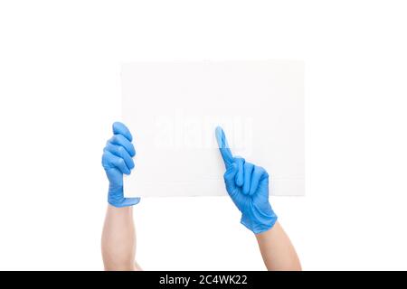 protest symbol empty cardboard paper hold hands in blue medical glove and pointing finger to empty poster, concept mockup strike paramedics medical cr Stock Photo