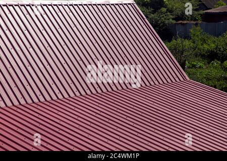 gable roof top view, roof overlap with corrugated metal of red color. Stock Photo