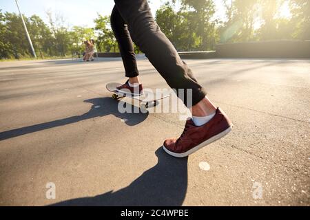 Close-up of skateboarders feet while skating in skate park. Man riding on skateboard. Isolated view, low angle shot. Stock Photo