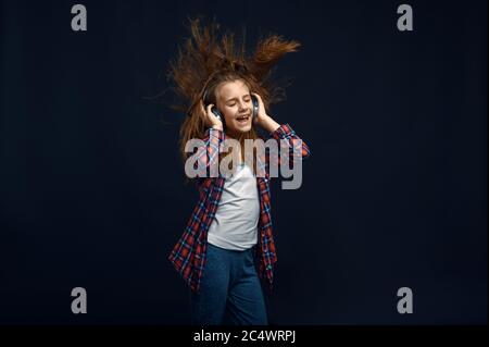 Little girl in headphones, developing hair Stock Photo