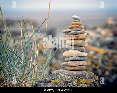 A balanced, stacked pile of stones and pebbles on a beach in East Lothian, Scotland, UK. Stock Photo