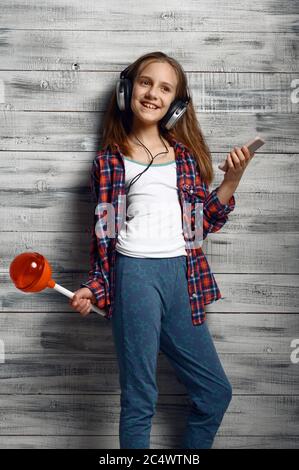 Little girl in headphones holds big lollipop Stock Photo