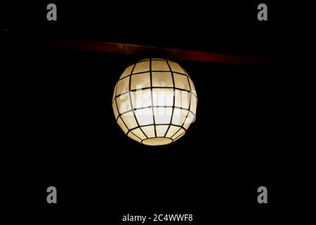 In the dark room the lamp hangs on the ceiling Stock Photo