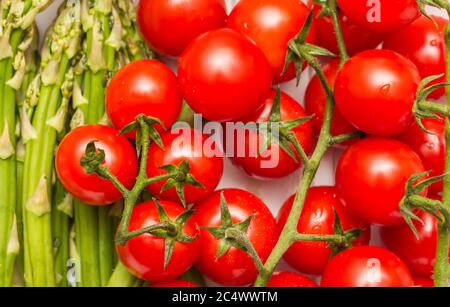 Closup of cherry tomatoes and green asparagus Stock Photo