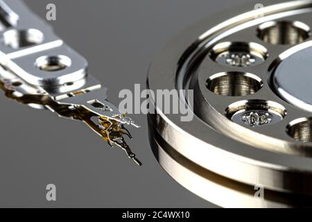 Macro shot of a magnetic needle on a hard disk platter, open HDD disk, perfectly clean surface. Stock Photo