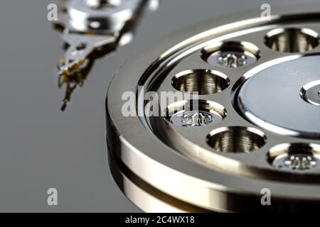 Macro shot of a magnetic needle on a hard disk platter, open HDD disk, perfectly clean surface. Stock Photo