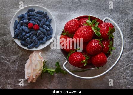 Top view of fresh strawberries and honeysuckle, small depth of sharpness Stock Photo