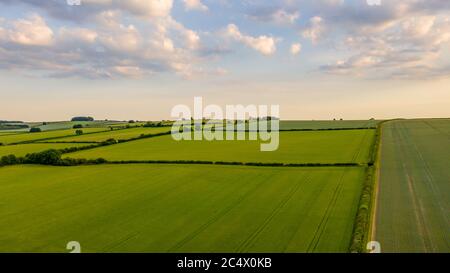 Aerial view across green fields to the horizon and cloudy blue sky over Oxfordshire