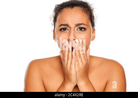 portrait of young dark-skinned shocked woman on white background