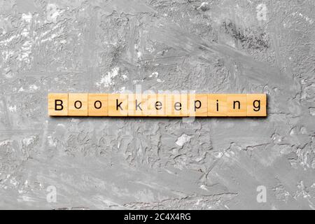 bookkeeping word written on wood block. bookkeeping text on table, concept. Stock Photo