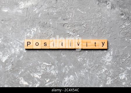 positivity word written on wood block. positivity text on cement table for your desing, concept. Stock Photo