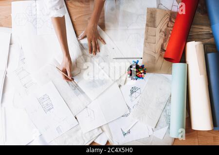 Close up woman drawing sketches on floor with colorful whatman papers near at home isolated Stock Photo