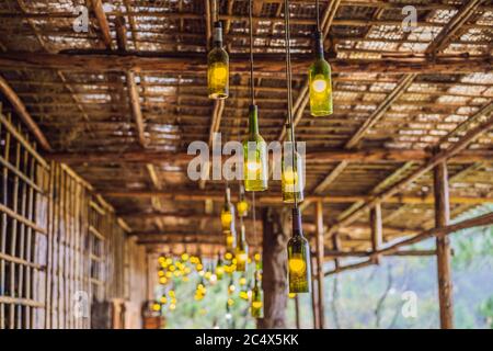 Beautiful retro light lamp decor made of empty wine bottles. Toned Stock Photo