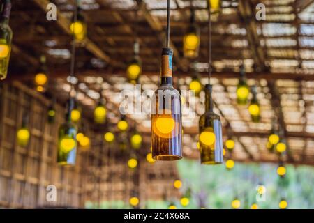 Beautiful retro light lamp decor made of empty wine bottles. Toned Stock Photo