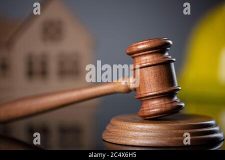Law theme. Construction law's symbols  - yellow helmet, house model and gavel. Stock Photo