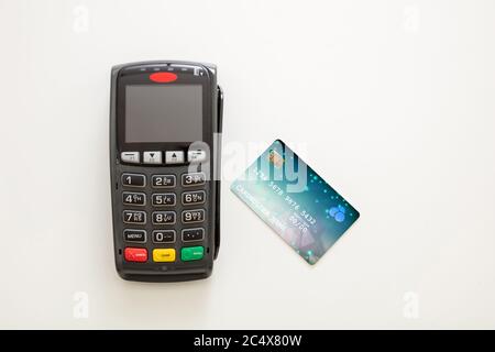 POS terminal and credit card isolated on white background, top view.Terminal cash register machine for contactless payment. Banking equipment, NFC. Stock Photo