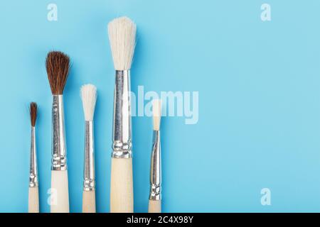 Brushes for drawing made of natural wood and wool. on a blue background. Stock Photo