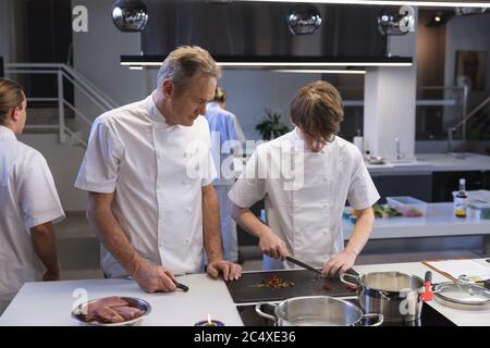 Senior and young chefs working at restaurant kitchen Stock Photo