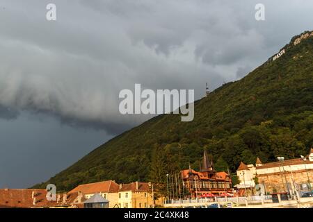 BRASOV, ROMANIA - Circa 2020: Storm clouds building up over a green hill. Concept of wild weather. Storm season. Stock Photo