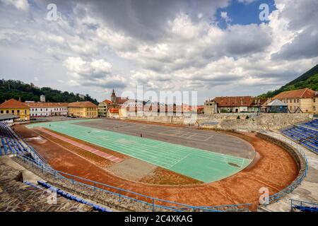 BRASOV, ROMANIA - Circa 2020: empty sport stadium and running track with moody cloudy sky. Concept of outdoor activities. No outdoor activity due to l Stock Photo