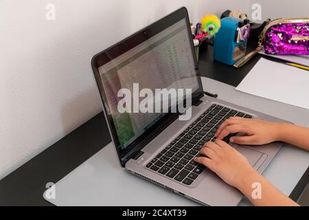A young student makes use of a laptop for her e-learning class. Stock Photo
