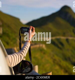 Woman photographing a landscape, Puy Mary, Cantal, Auvergne-Rhone-Alpes, France Stock Photo