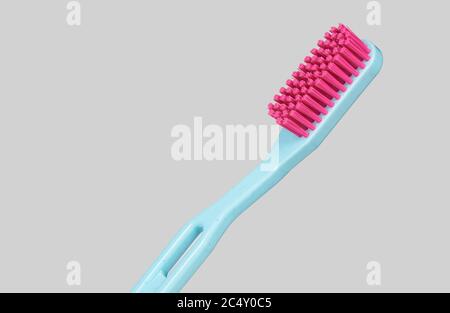 blue and pink plastic toothbrush sideways isolated on a grey background Stock Photo