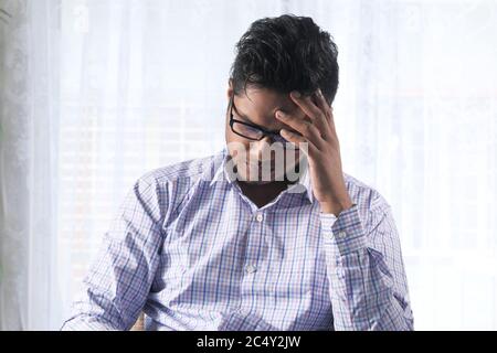Depressed man feeling sick and worried about financial problem Stock Photo