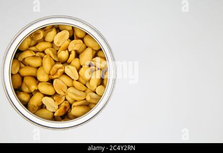 Top view close up of isolated open can with roasted salted peanuts, white background Stock Photo